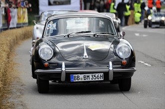 A black Porsche classic car takes part in a street race with spectators, SOLITUDE REVIVAL 2011,