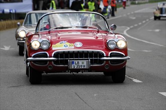 A red Corvette Cabriolet at a street race, surrounded by spectators, SOLITUDE REVIVAL 2011,