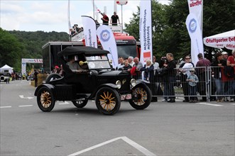 A black Ford Model T vintage car drives in front of spectators at a historic car race, SOLITUDE