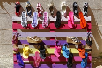 The bay of Port Miou in Cassis, A colourful bench with different shoes displayed in the sunlight,