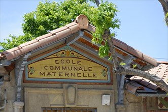 Marseille, sign of the Ecole Communale Maternelle with a tree and traditional architectural