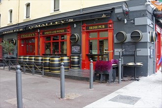 Marseille, Facade of an Irish pub with red colour and barrels in front of the entrance, Marseille,