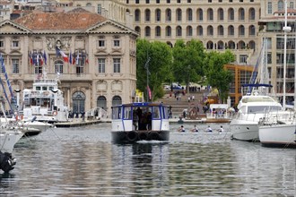 Marseille harbour, view over a harbour with a ferry, boats and buildings in the background,
