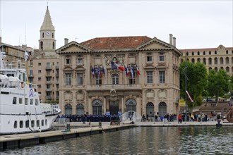 Old, historic town hall building at the harbour with boats in the foreground, Marseille,