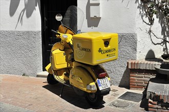 Solabrena, A yellow Correos scooter is parked and ready for mail delivery in Spain, Andalusia,