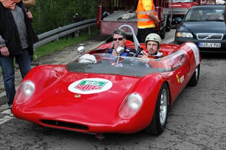 Two people in a classic red racing car on a race track, SOLITUDE REVIVAL 2011, Stuttgart,