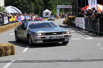 A silver DeLorean drives on a road during a classic car race, SOLITUDE REVIVAL 2011, Stuttgart,