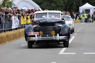 A black vintage car on a race track accompanied by a dense crowd, SOLITUDE REVIVAL 2011, Stuttgart,
