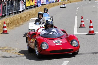 Red racing car driven by a driver with helmet in a field of drivers, SOLITUDE REVIVAL 2011,