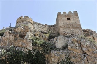 Solabrena, Old castle fortress on a rock with battlements and towers, signs of ruin and decay,