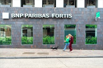 Shoppers walking past BNP Paribas Fortis bank office in the city centre of Ghent, Gent, East