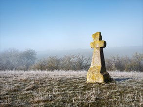 Medieval stone cross in hoarfrost and fog in winter, murder cross, atonement cross, Freyburg