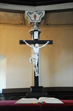 Langenburg Castle, A cross with a figure of Jesus above an altar in a church devotional setting,