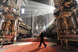 Speyer Cathedral, A person walks through the church aisle while rays of light illuminate the