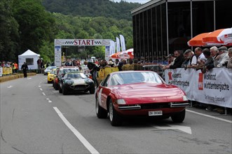 A green vintage sports car stands in front of the starting line of a road race, SOLITUDE REVIVAL