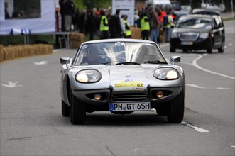 A white Marcos sports car on the road at a rally, SOLITUDE REVIVAL 2011, Stuttgart,
