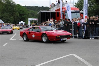 A red classic car at a motorsport event in front of an enthusiastic audience, SOLITUDE REVIVAL