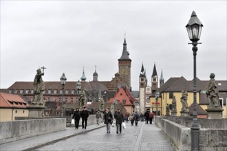 Wuerzburg, View of a busy street with statues and historic buildings in a European old town,