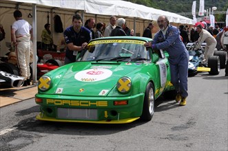 A green Porsche classic car with the number 1 and yellow accents at a race, SOLITUDE REVIVAL 2011,