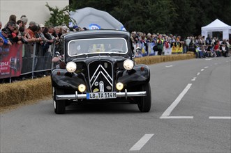 A classic black Citroen drives in front of spectators at a classic car race, SOLITUDE REVIVAL 2011,