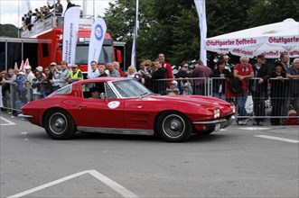 Red vintage sports car drives past a group of spectators at an event, SOLITUDE REVIVAL 2011,