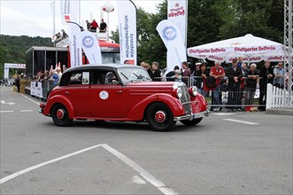 A red vintage car drives past a crowd at an event, SOLITUDE REVIVAL 2011, Stuttgart,