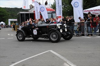 A black vintage car drives past spectators at a racing event, SOLITUDE REVIVAL 2011, Stuttgart,
