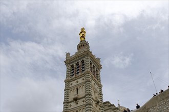 Madonna, Church of Notre-Dame de la Garde, Marseille, A tall church tower with a gold-coloured