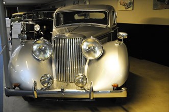 Deutsches Automuseum Langenburg, A grey, closed vintage car with chrome details is illuminated in