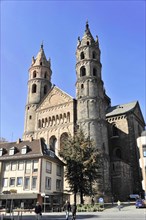 Speyer Cathedral, A large church with two towers under a blue sky, surrounded by trees and