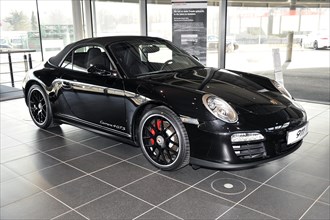 A black Porsche 911 Coupe on display in a showroom, Schwaebisch Gmuend, Baden-Wuerttemberg,