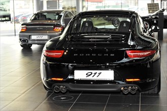 The rear view of a shiny black Porsche 911 in a car dealership, Schwaebisch Gmuend,