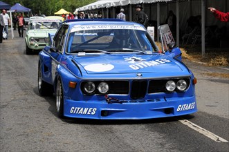 A blue BMW racing car with advertising lettering parked on a street, SOLITUDE REVIVAL 2011,