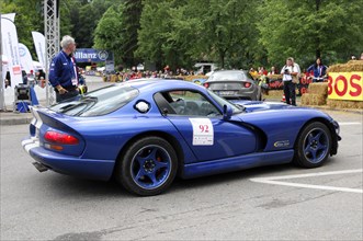 A blue sports car with racing number at a classic car race surrounded by spectators, SOLITUDE