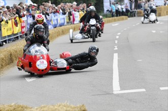A red sidecar motorbike in a race, teamwork of rider and passenger, SOLITUDE REVIVAL 2011,