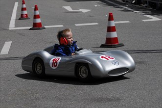 Child concentrates while driving a racing soapbox on a road course, SOLITUDE REVIVAL 2011,