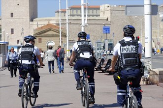 Police officers on bicycles patrolling a city street, Marseille, Bouches-du-Rhone department,