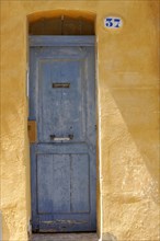 Marseille, Old faded blue door in a yellow plaster facade with the house number 37, Marseille,