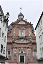 Neumuenster Collegiate Abbey, Diocese of Wuerzburg, red baroque church facade with sculptures,