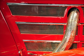 Close-up of the radiator grille of a red classic car with striking chrome details, Mercedes-Benz