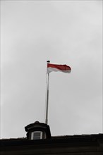 Langenburg Castle, A waving flag on a flagpole against a grey, cloudy sky, Langenburg Castle,
