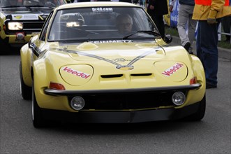 A yellow sports car with racing numbers and sponsor logos during a race, SOLITUDE REVIVAL 2011,