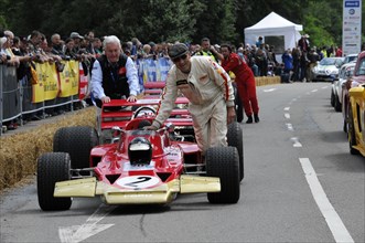 A red formula racing car is pushed by helpers on a race track, SOLITUDE REVIVAL 2011, Stuttgart,