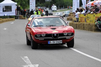 A red Alfa Romeo sports car on the road at a classic car rally, SOLITUDE REVIVAL 2011, Stuttgart,