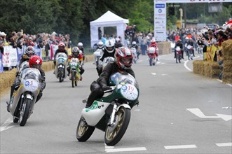 Motorcyclists compete on the race track, surrounded by spectators, SOLITUDE REVIVAL 2011,