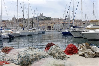 Marseille harbour, Colourful sailing boats and fishing boats in the harbour, red fishing nets in
