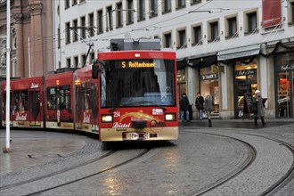 Wuerzburg, Red tram moves through the city centre of Wuerzburg along the tracks, Wuerzburg, Lower