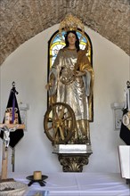 Castillo de Santa Catalina in Jaen, A golden statue of a saint with a wheel in a church, Granada,