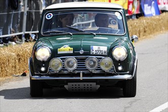 A green classic Mini Cooper in a street race surrounded by spectators, SOLITUDE REVIVAL 2011,