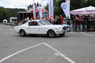 A white Ford Mustang drives past spectators at a classic car race, SOLITUDE REVIVAL 2011,